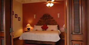 A bedroom with a large bed, a ceiling fan, and a nightstand with a lamp. - Family Oriented - Private Beach & Horse Stables - Ocean, Pool, & Hot Tub (Cabrera)