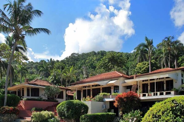 A resort with multiple buildings, a red-roofed structure, and lush greenery.