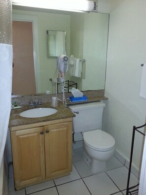 A bathroom with a sink, mirror, towel rack, and toilet. - Hollywood Beach Resort- Large Studio Sleeps 4 (Hollywood)