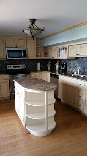 A kitchen with a central island, stainless steel appliances, and wooden cabinets. - Hollywood Beach Resort-tower Suite (Hollywood)
