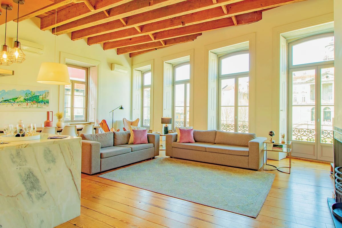 A spacious living area with a marble countertop, two sofas, and a large window providing natural light.