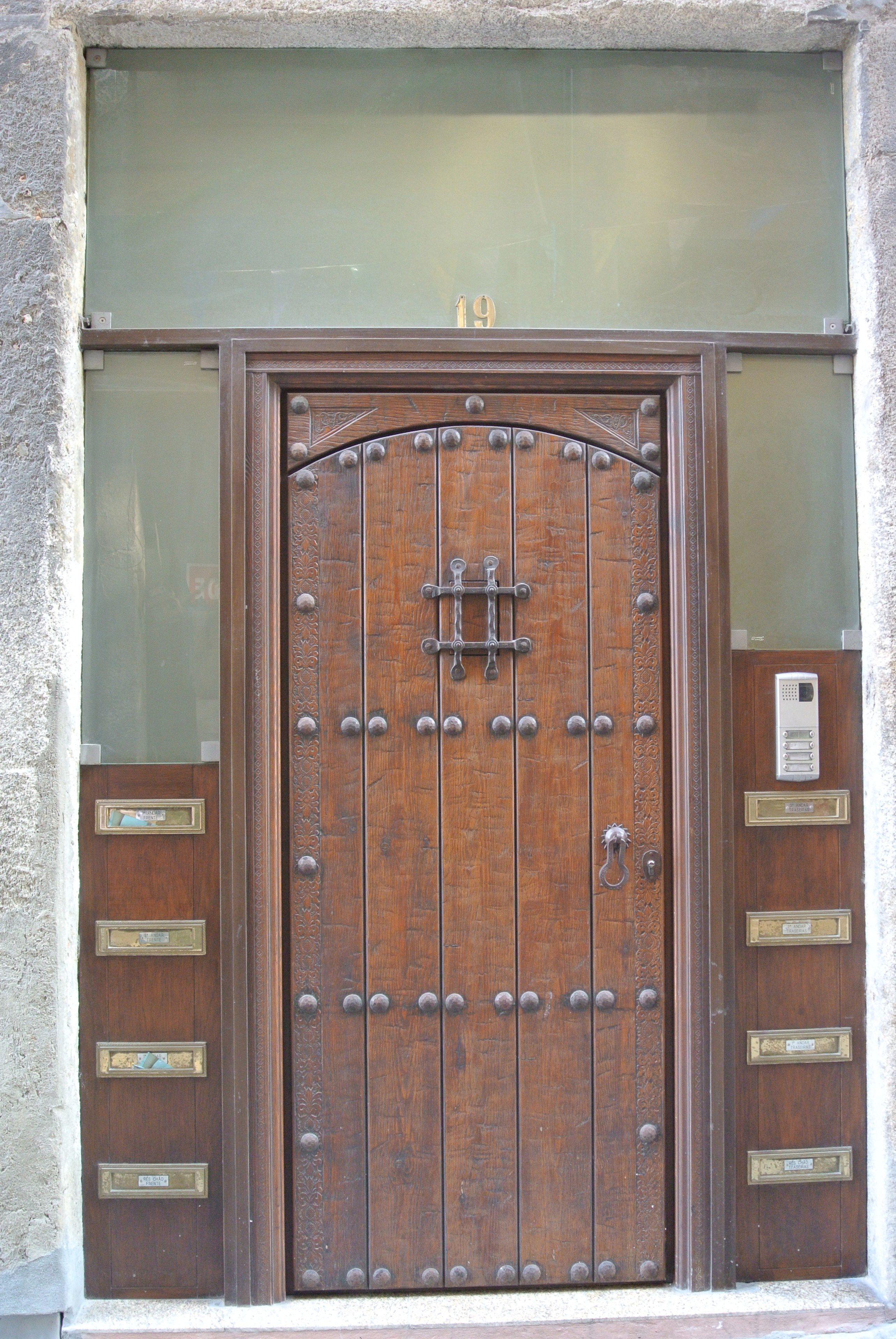 A wooden door with a brass handle and a mail slot.