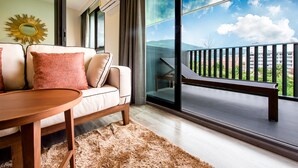 Un salón moderno con un sofá, una mesa de madera y vistas a un balcón con barandilla.