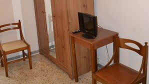 A room with a wooden wardrobe, a small table with a television, and two wooden chairs. - Albergo Abruzzese (Riano)