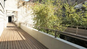 A wooden deck with a stone wall and a metal railing. - LUXURY VIEWS by YoursPorto (Vila Nova de Gaia)