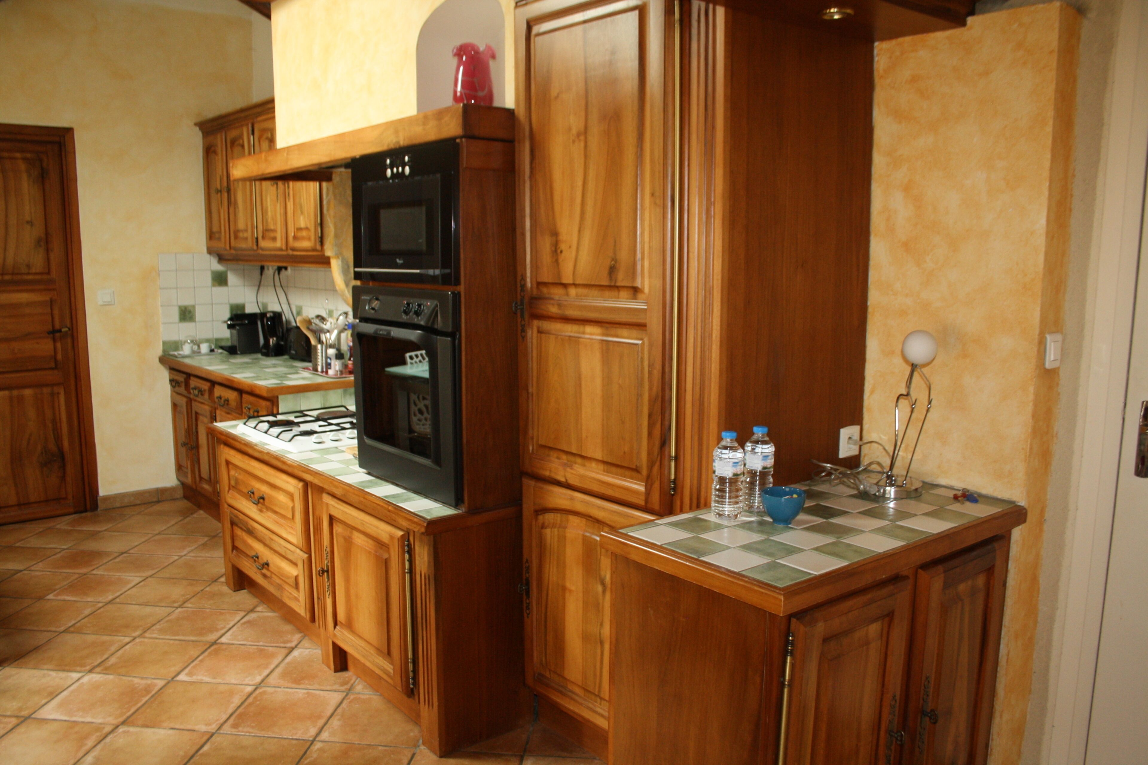 Una cocina con armarios de madera, estufa a gas, horno y microondas.