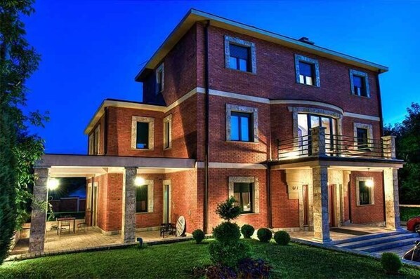 A multi-story brick house with a covered patio and a balcony. - The Belgrade Hills (Belgrade)