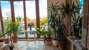 A balcony with potted plants, a small table, and a view of the outside. - The Belgrade Hills (Belgrade)