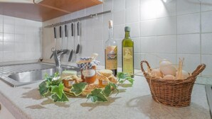 Een keuken met een roestvrijstalen spoelbak, een fles olijfolie, een mand met eieren en een schaal met honingpotjes.