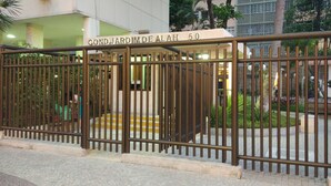 A gated entrance with a sign reading "COND. JARDIM DE ALAH 50". - Leblon Apartment (Rio de Janeiro)