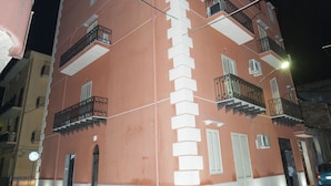 A multi-story building with balconies and a staircase leading to the entrance. - B&B Del Centro (Partinico)