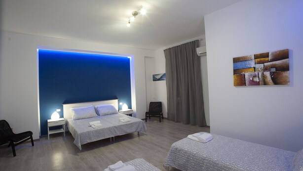 A hotel room with two beds, a desk, a chair, and a wall-mounted artwork. - B&B Del Centro (Partinico)