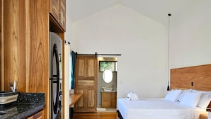 Een slaapkamer met een houten hoofdbord, een groot bed en een nachtkastje.