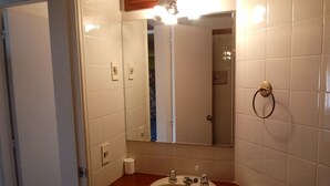 Ein Badezimmer mit Waschbecken, Spiegel und Handtuchhalter.