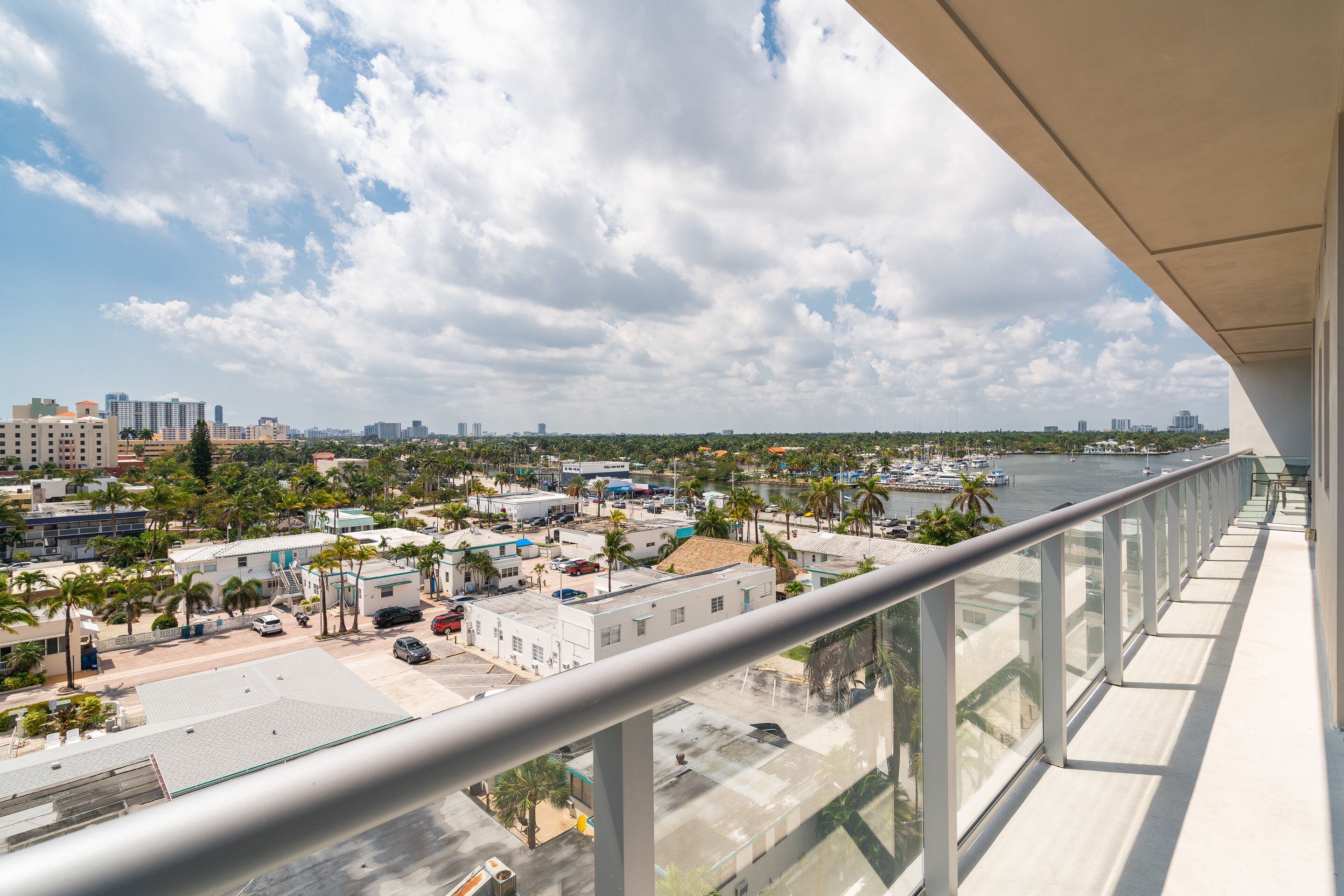 Un immeuble de grande hauteur doté d’un balcon donnant sur une marina et sur le paysage urbain.