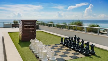 Een schaakbord op een terras op het dak, met uitzicht op de oceaan.