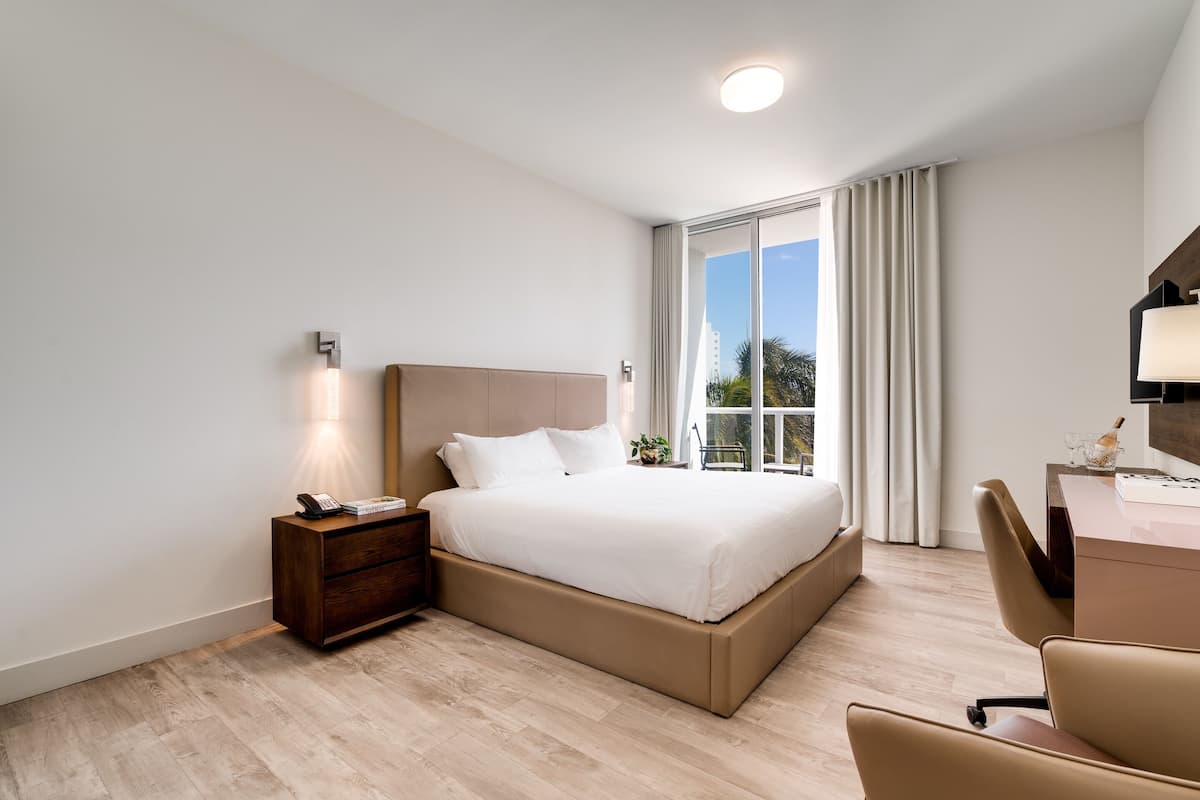 Une chambre d’hôtel moderne, dotée d’un grand lit, d’un bureau et d’une chaise.
