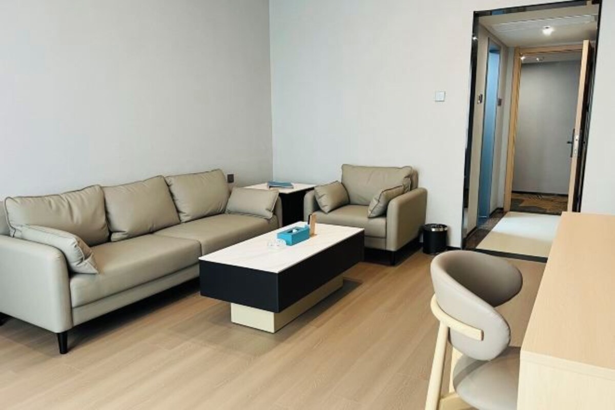 A modern living room with a sofa, coffee table, and a small table.
