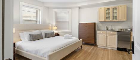 Ein Schlafzimmer mit einem Bett, Nachttischen und Holzboden.