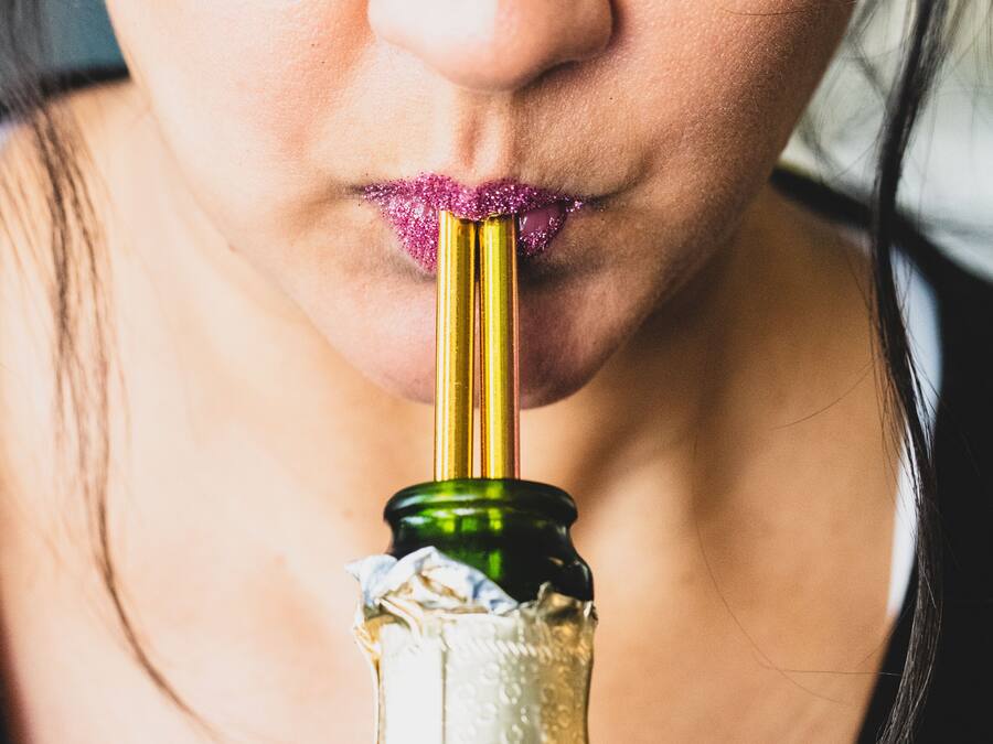 Gros plan sur une bouteille de champagne, recouverte d’une feuille d’or et portant une étiquette sur laquelle on peut lire « CHAMPAGNE ».