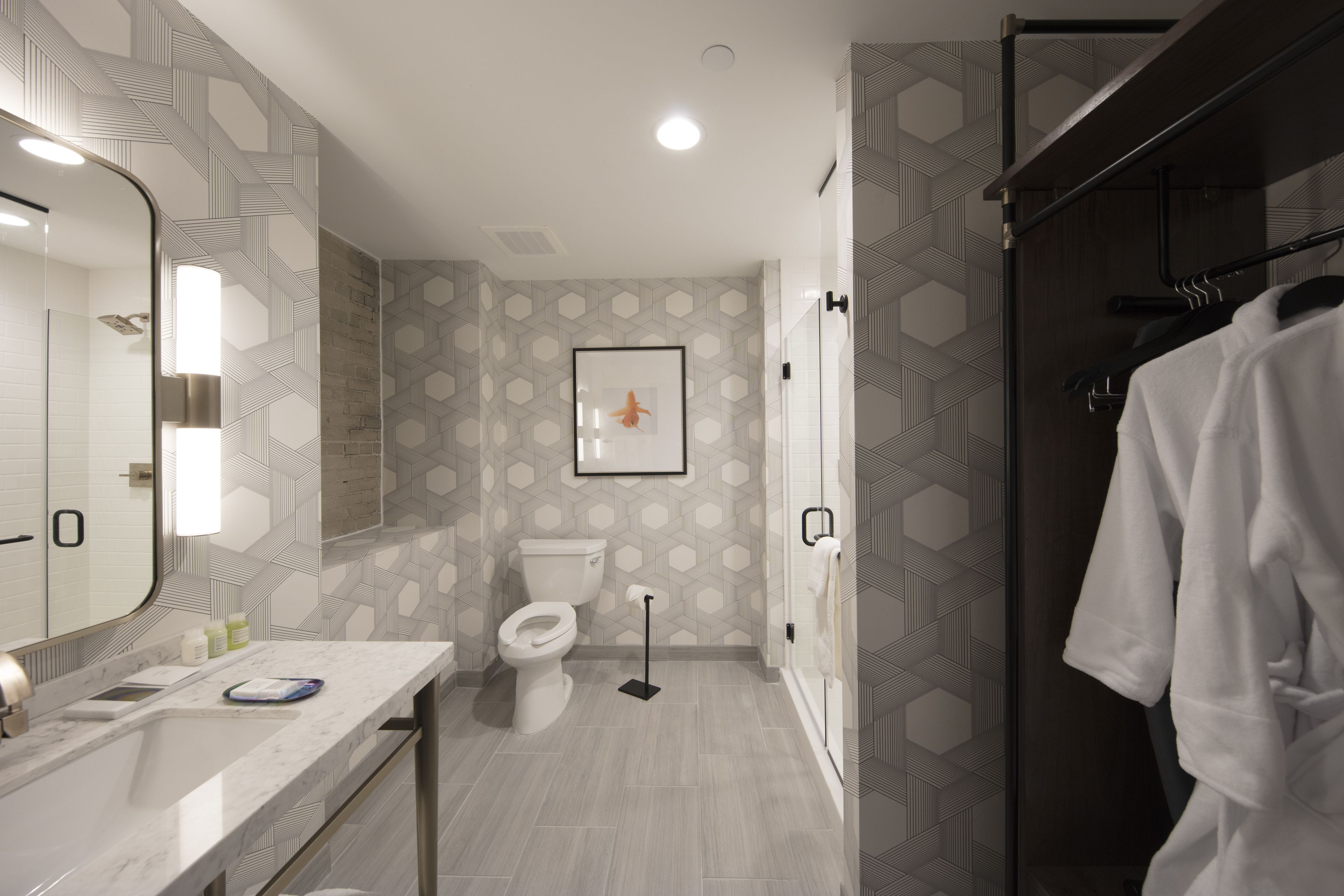 Een moderne badkamer met een grote spiegel, toilet en douchehoek.