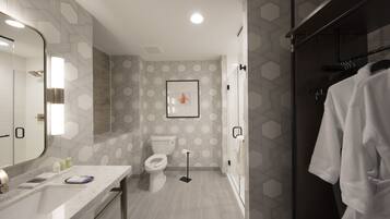 Een moderne badkamer met een grote spiegel, toilet en douchehoek.