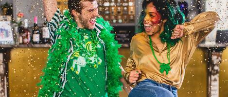 Two people celebrating with confetti in a bar setting.