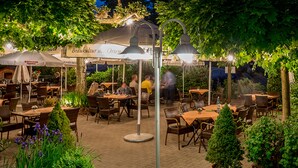 An outdoor restaurant with tables and chairs, surrounded by greenery and under a canopy. - Hotel Linde Durbach (Durbach)