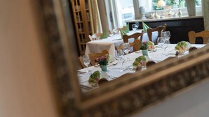 A dining table set with white tablecloths, green napkins, and wine glasses. - Hotel Linde Durbach (Durbach)