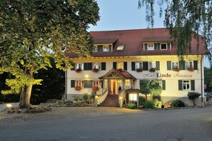 A two-story building with a sign reading "Hotel Linde Restaurant." It features a red-tiled roof, multiple windows with shutters, and a staircase leading to the entrance. - Hotel Linde Durbach (Durbach)