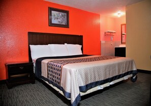 A hotel room with a single bed, a nightstand, a framed picture on the wall, and a bathroom with a mirror and towel rack. - 4 Star Motel (Los Angeles)