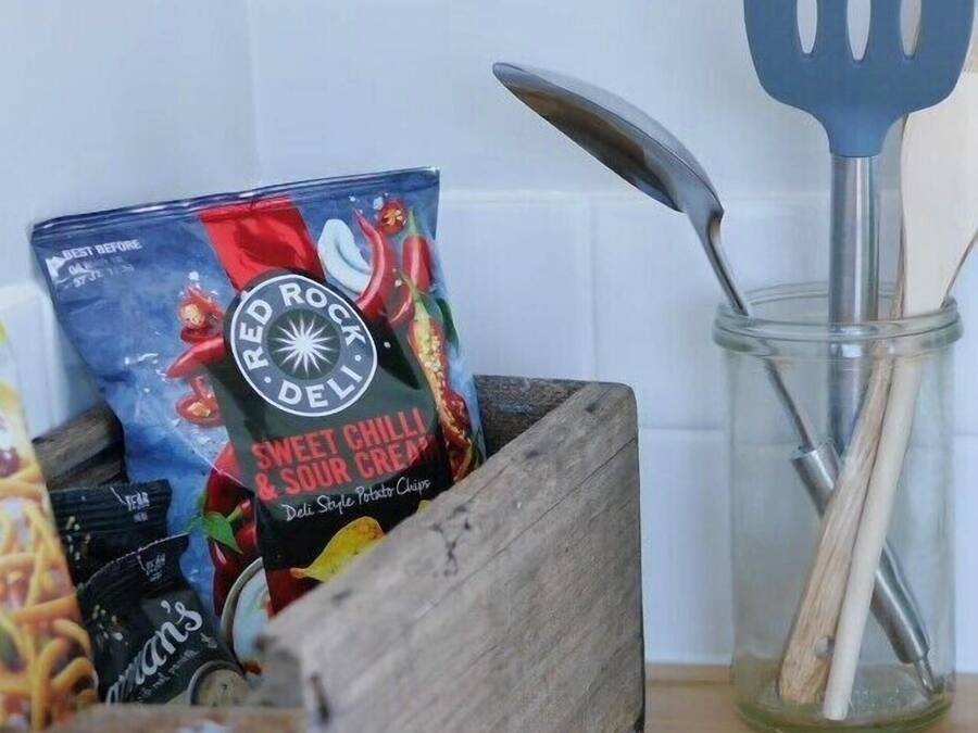 Une boîte en bois contenant des aliments et une spatule en métal dans un bocal en verre.