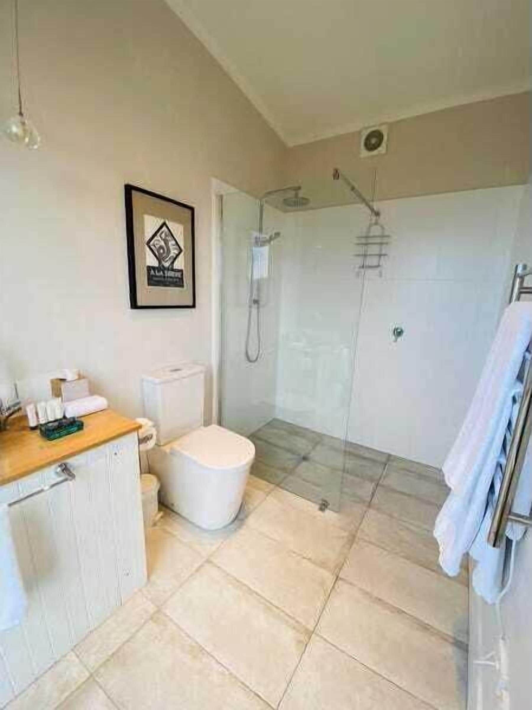 A bathroom with a toilet, sink, and shower.