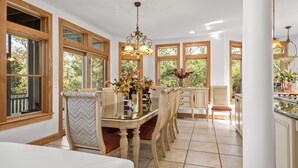 Ein Essbereich mit Holztisch, Stühlen und einer Chandelüster.