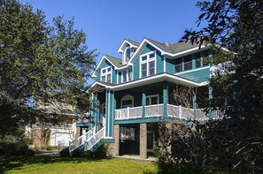 A large, two-story house with a balcony and a covered front porch.