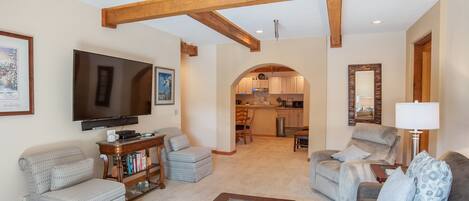 A living room with a television, seating, and a coffee table.