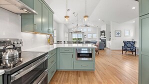 Une cuisine moderne dotée d’appareils électroménagers en acier inoxydable, de meubles de couleur bleu clair et d’un îlot central.