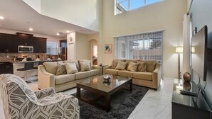 A spacious living area with a sofa set, a coffee table, and a TV.
