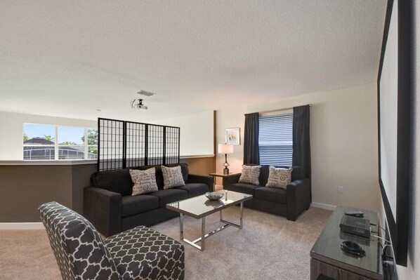 A living room with a sofa set, a coffee table, and a TV stand.