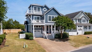 Een huis met twee verdiepingen, een balkon, een veranda en een garage.