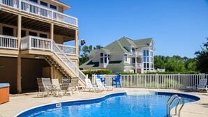 A swimming pool with lounge chairs and a staircase leading to a balcony. - Y7 Fairways & Sunsets: Pool, Spa, Elevator (Corolla)
