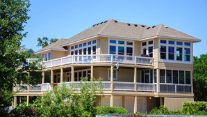 A two-story house with a balcony on the upper floor. - Y7 Fairways & Sunsets: Pool, Spa, Elevator (Corolla)