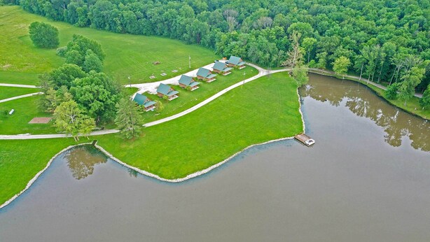 A lakeside property with multiple cabins, a dock, and a well-maintained lawn. - Lakefront Vacation Rental w/ Patio & Grill! (Columbia)