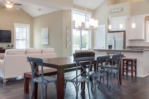 A modern kitchen with a dining area, a large window, and a sign that reads "BEACH".