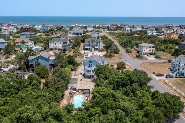 A residential area with houses, a swimming pool, and a road.