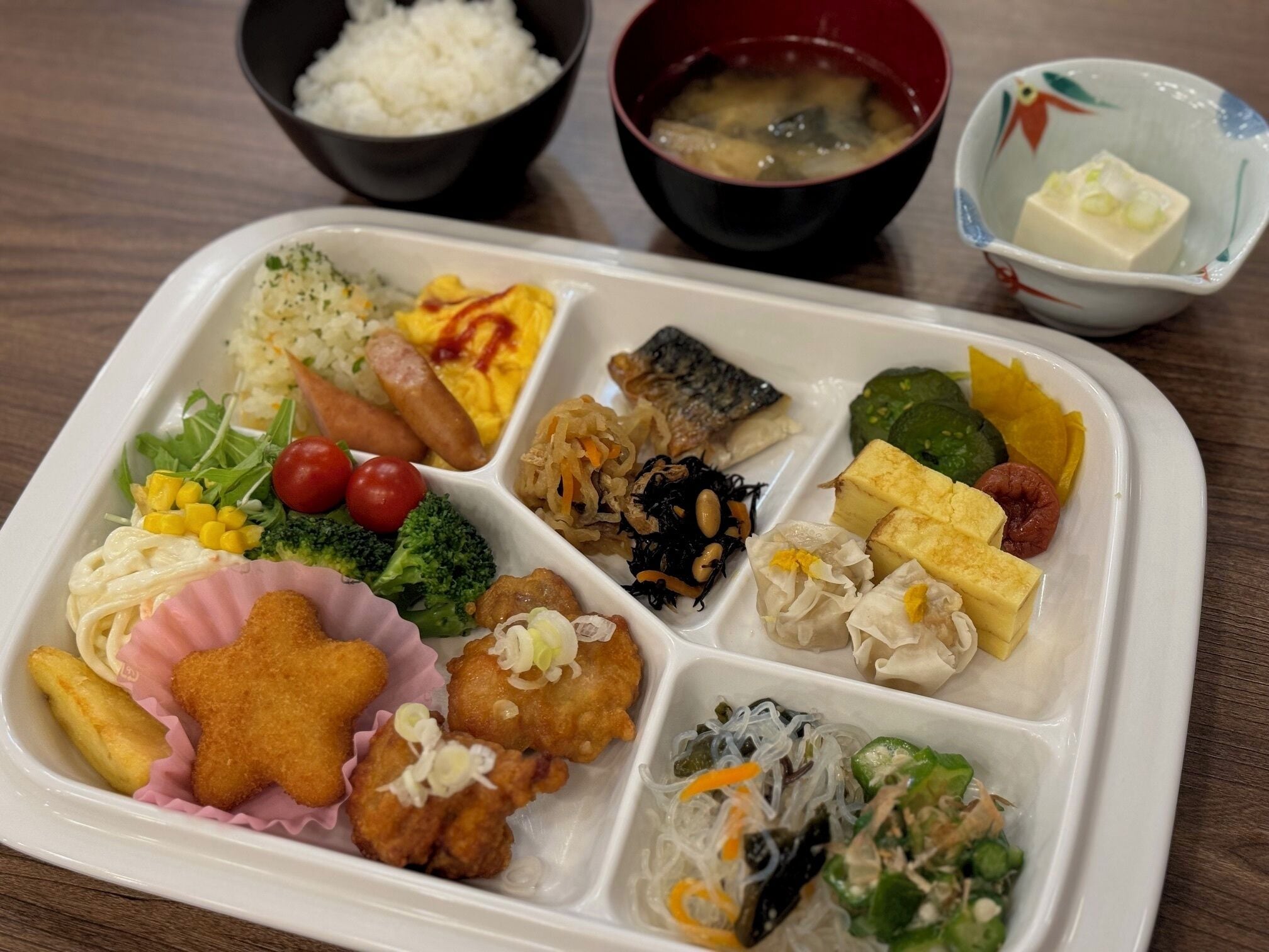 A meal tray with various dishes including rice, vegetables, and tofu.