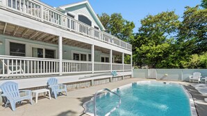 A two-story building with a pool, outdoor seating, and a covered patio area. - The Tipsea Turtle: Pool, & Hot Tub (Corolla)