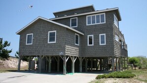 A two-story building with a gabled roof and multiple windows. - Merry Winds: Oceanfront, Shared Pool, Great Views (Corolla)
