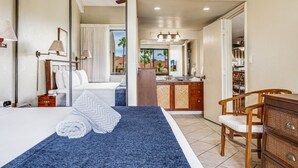 A bedroom with a bed, a desk, and a chair.