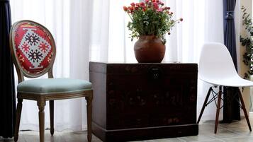Ein Zimmer mit einem Holzkasten, einem Sessel und einem weißen Stuhl.